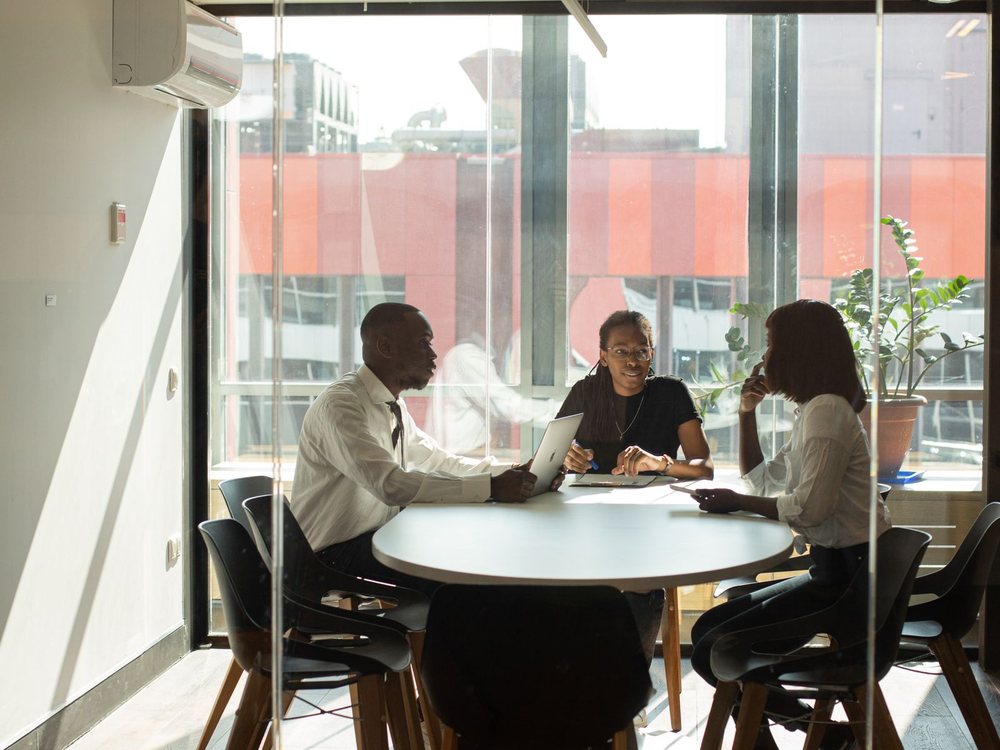 Colleagues in discussion around a table in an office